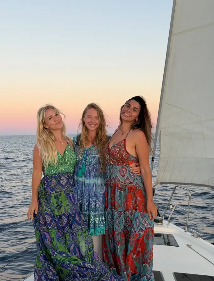 Three friends enjoying golden hour on a sailboat