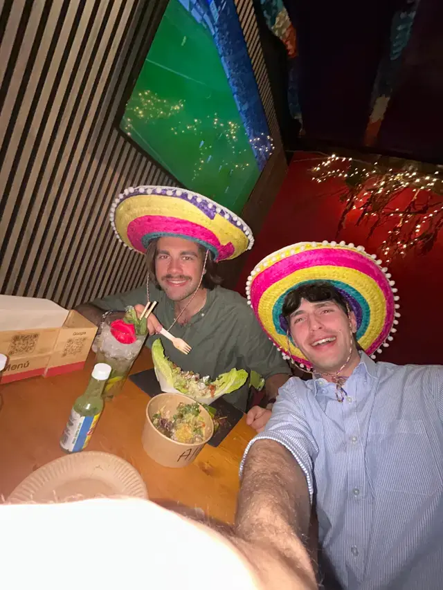 Two guests in bright sombreros sharing a meal